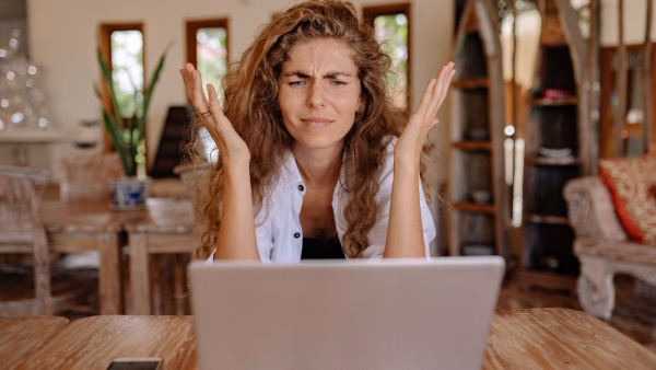 A Brisbane small business owner looking frustrated at a laptop screen asking why is my business not showing on Google search results — OceanSky Digital